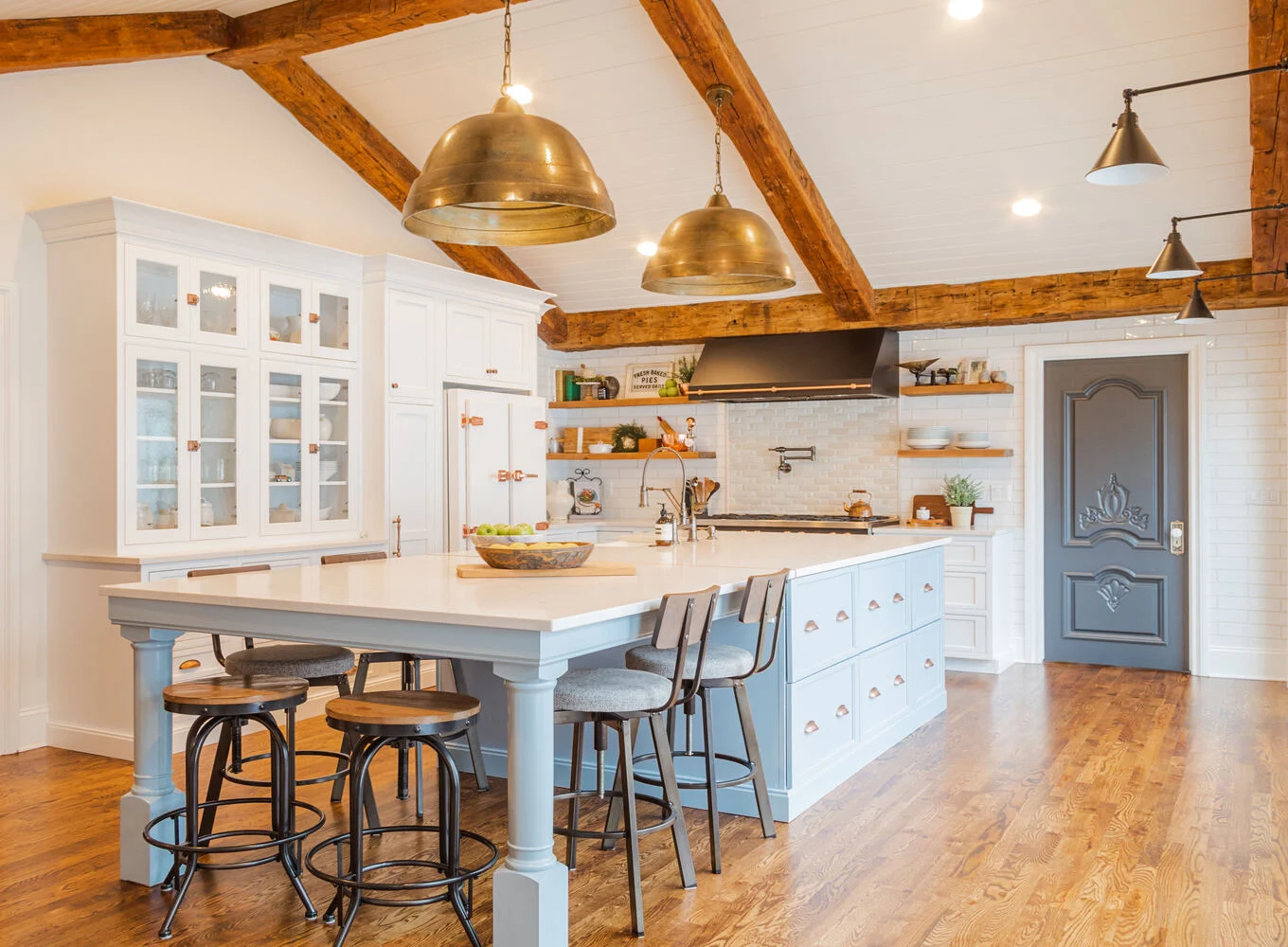 Wide-angle view of custom kitchen design by Cabinet Creations in Clarkston, MI featuring blue island and wood floors