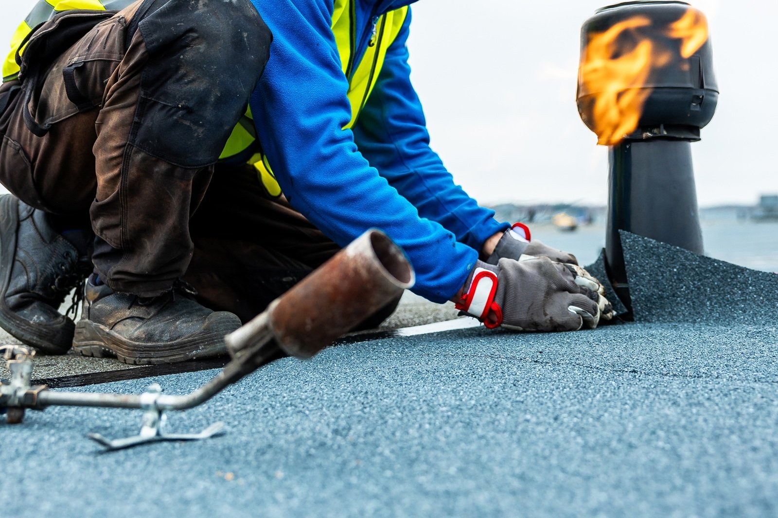 A,Worker,In,A,High,Visibility,Vest,Kneels,On,A